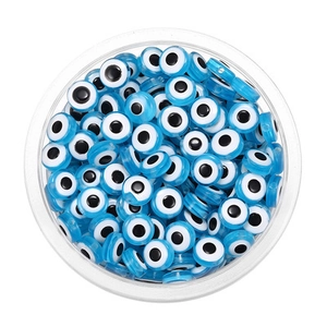 Perles mauvais œil bleu clair en acrylique empilées dans une boîte transparente pour bijoux