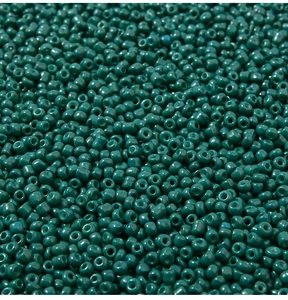Vista macro di perline verde petrolio lucide per creazione di gioielli fai-da-te