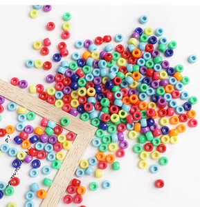 Perline cilindriche colorate in acrilico per creazione gioielli fai-da-te su bianco