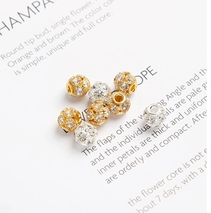 Vue macro de perles rondes creuses en zircon or et argent pour création de bijoux DIY