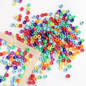 Perline cilindriche colorate in acrilico per bracciali e collane fai da te su sfondo bianco