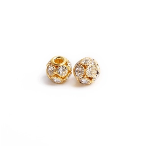 Détail de breloques sphériques dorées avec zircons clairs pour création de bijoux DIY