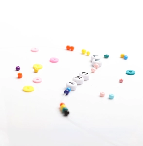 Détail macro de perles alphabet LUCKY et perles colorées pour la création de bijoux DIY