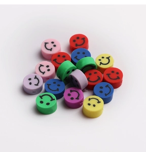 Gros plan de perles colorées en pâte polymère avec smileys pour bijoux DIY