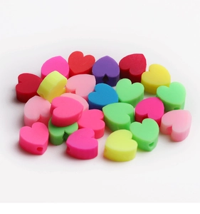 Gros plan de perles colorées en forme de cœur pour bijoux DIY avec trous pré-percés