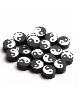 Vue macro de perles en pâte polymère motif Tai Chi Yin Yang noir et blanc pour bijoux DIY