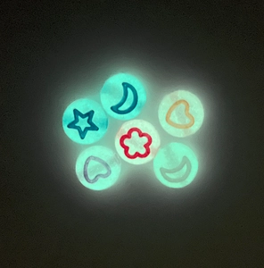 Vue macro de perles acryliques lumineuses avec motifs d'étoiles et de lunes