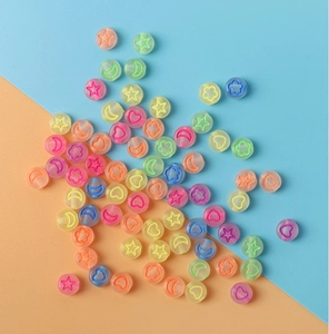 Détail de perles en acrylique colorées avec étoiles et lunes pour bijoux DIY