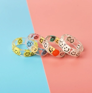 Set of four transparent resin rings with colorful smiley face patterns in Y2K style