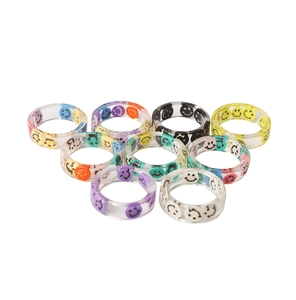 Macro shot of colorful resin smiley face rings in various transparent shades for adults