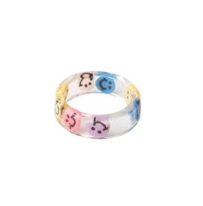 Macro detail of transparent resin ring with colorful smile face patterns inside