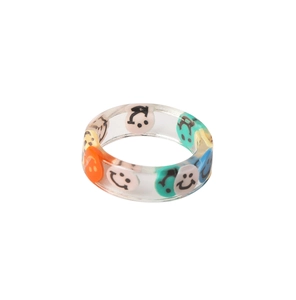 Macro shot of colorful resin rings with embedded smiley face patterns on white backdrop