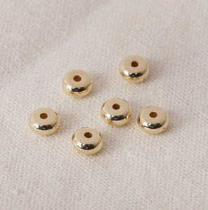 Macro view of six polished golden CCB spacer beads with holes for DIY jewelry making