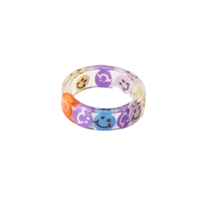 Macro detail of transparent resin ring featuring colorful embedded smiley face patterns