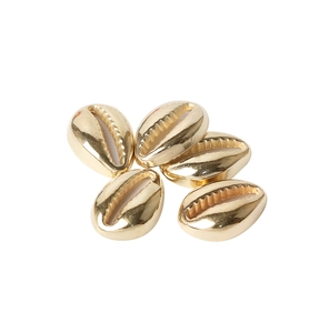 Close-up of five shiny golden shell-shaped beads for DIY jewelry making and crafts