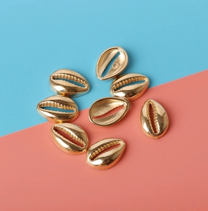 Close-up of golden CCB shell beads for DIY jewelry making on a pastel blue background
