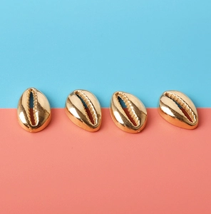 Detailed view of four golden shell-shaped CCB beads for DIY jewelry making and crafts