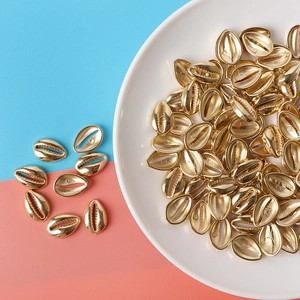Golden seashell beads for DIY jewelry with electroplated metal finish on ceramic plate