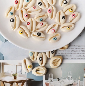 Macro detail of colorful shell evil eye beads for handmade DIY jewelry crafting on a white plate