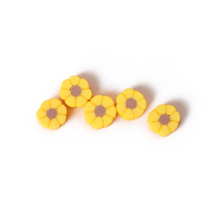 Détail macro de cinq perles marguerites jaunes en pâte polymère pour la création de bijoux