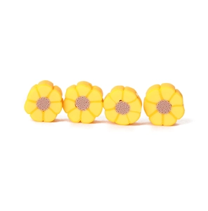 Vue détaillée de quatre perles marguerites jaunes en pâte polymère pour la création de bijoux