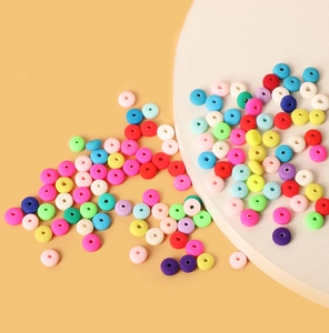 Cuentas espaciadoras planas de arcilla polimérica de colores para joyería DIY sobre fondo