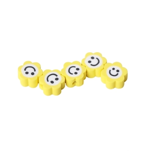 Macro de cinq perles de fleurs jaunes en pâte polymère avec visages souriants pour bijoux