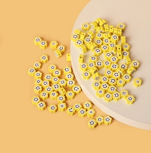 Détail macro de perles smiley de tournesol en pâte polymère jaune pour bijoux DIY