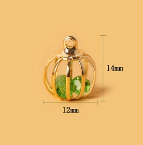 Detailansicht eines 14mm goldenen Hohlkugel-Anhängers mit grünen Kristallen zum Basteln