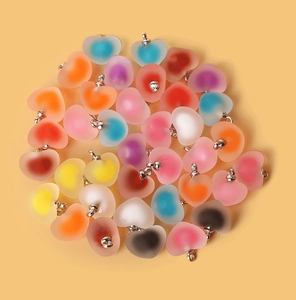 Macro shot of colorful frosted acrylic heart pendants with silver loops for DIY jewelry