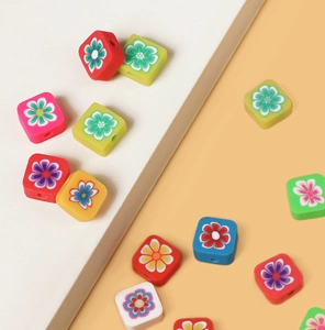 Detailed view of colorful square polymer clay beads with floral prints for DIY jewelry