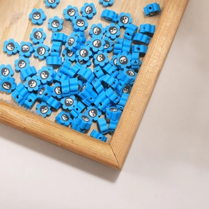 Blue flower polymer clay beads with yin yang patterns for DIY jewelry making in a tray
