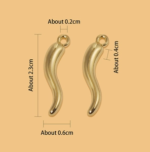 Detailed size view of two gold curved horn pendants with dimensions 2.3cm by 0.6cm