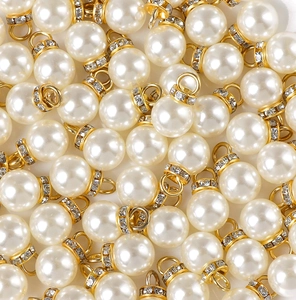 Vista macro di ciondoli con perle finte e cappucci in oro con strass per gioielli fai da te