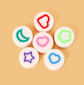 Gros plan de perles en pâte polymère colorées avec motifs cœur étoile lune pour bijoux