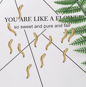 Flat lay of matte gold horn-shaped alloy charms for DIY jewelry making and crafts