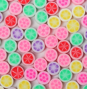 Vue à plat de perles colorées en pâte polymère fruits et fleurs pour bijoux DIY
