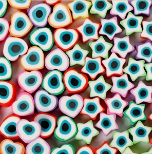 Gros plan de perles en pâte polymère en forme de cœur et d'étoile avec motifs mauvais œil