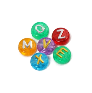Macro-opname van gekleurde acryl alfabet kralen met goud en zilver reliëf voor DIY sieraden