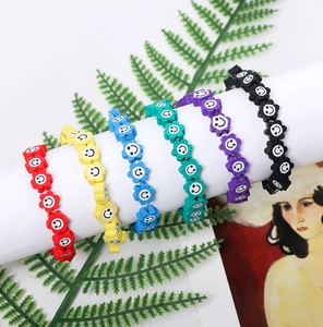 Détail de bracelets colorés en perles de tournesol souriant sur support blanc