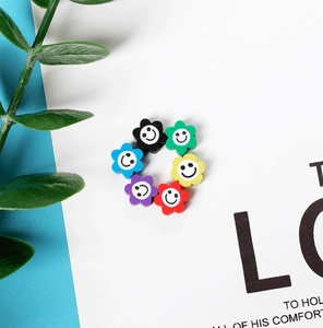 Vue macro de perles fleurs souriantes en pâte polymère colorée pour bijoux DIY