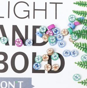Détail de perles plates en argile polymère de 10mm avec motifs de fleurs de frangipanier