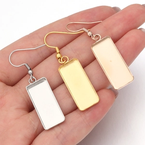 Close-up of rectangular stainless steel earring trays in gold and silver for DIY jewelry