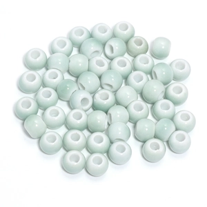Macro shot of light green glazed ceramic beads with white inner hole for DIY jewelry making