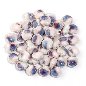 Makroaufnahme von muschelförmigen Keramikperlen mit blau-roter Glasur für DIY-Schmuck