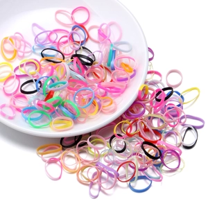Close-up of colorful high-elasticity hair bands in a white ceramic dish