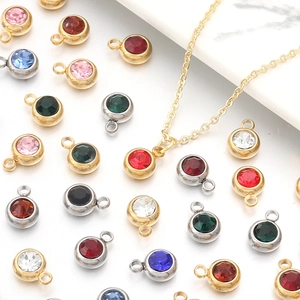 Macro view of multi-colored round birthstone charms with gold and silver plated bases