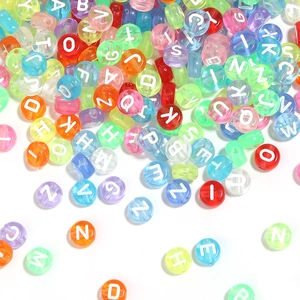 Gros plan de perles alphabet en acrylique coloré translucide pour la création de bijoux