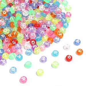 Vue macro de perles de lettres en acrylique translucide colorées pour bijoux DIY