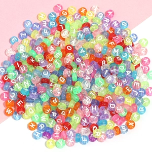Gros plan de perles alphabet en acrylique coloré avec lettres blanches pour bijoux DIY